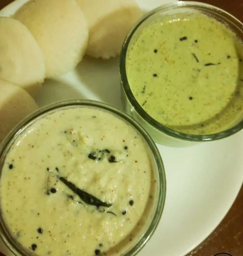A plate of Idli served with two types of coconut chutney: traditional coconut chutney and cilantro coconut chutney