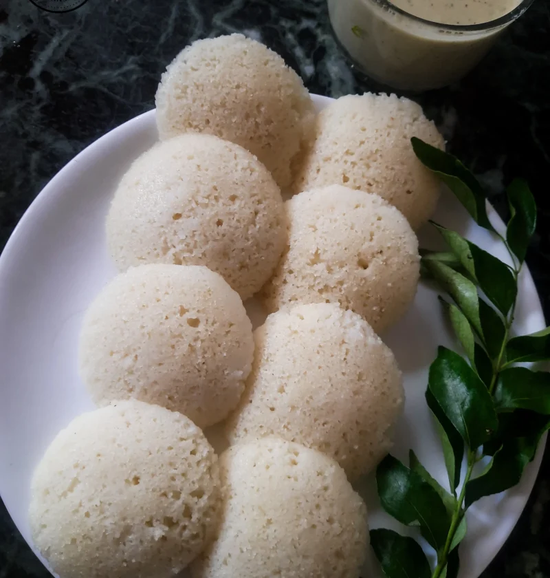 Delicious Rava Idli Served with Coconut Chutney and Fresh Curry Leaves
